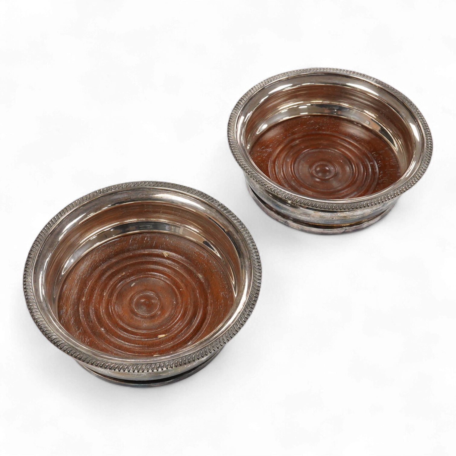 A pair of Elizabeth II silver mounted wine coasters, by C.J. Vander Ltd, London, 1961, overall diameter 15cm.